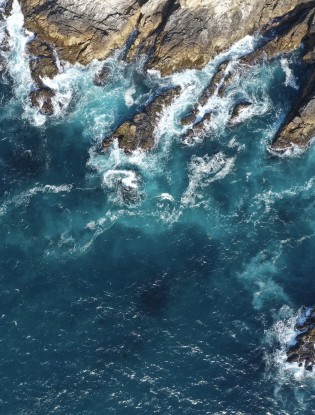 Aerial shot of coastline waves on rocks